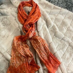Orange metallic scarf, colors are orange, gold, dark white, and a purplish color